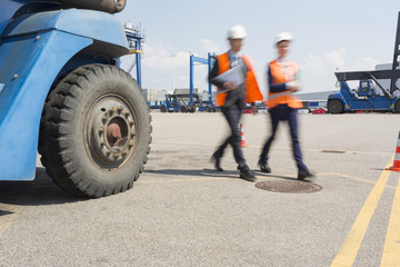 Blurred motion of workers walking in shipping yard