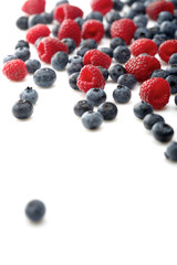 Raspberries and blueberries on white background