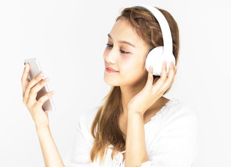  ワイヤレスヘッドホンとスマホで音楽を聴く女の子