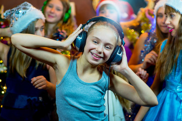 Obraz premium Group of cheerful young girls celebrating Christmas. Headphones