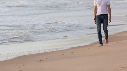 fashion model man walking on the sand beach, beautiful sea