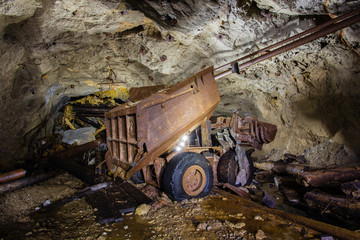 Fototapeta na wymiar Abandoned old ore mine shaft tunnel passage loading machine