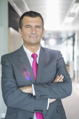 Naklejka premium Portrait of middle-aged businessman standing with arms crossed in office