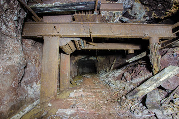 Fototapeta na wymiar Abandoned old ore mine shaft tunnel passage metal arming