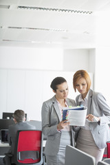 Businesswoman discussing over book in office