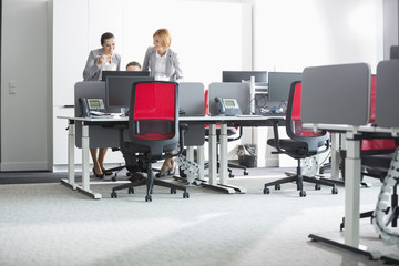 Business people having lunch while using computer in office