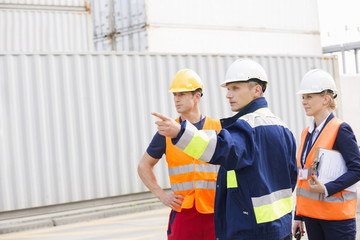 Workers discussing in shipping yard