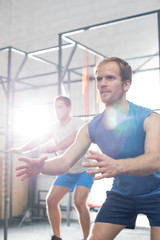 Fototapeta na wymiar Determined men exercising at crossfit gym