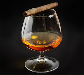 A glass of whiskey and cigar