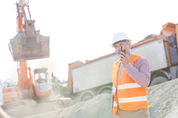 Architect using walkie-talkie while working at construction site