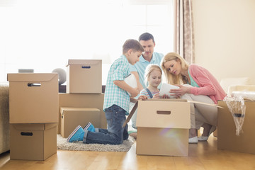 Fototapeta na wymiar Family unpacking cardboard boxes at new home