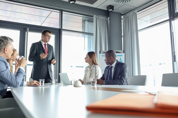 Mature businessman discussing with colleagues in meeting room