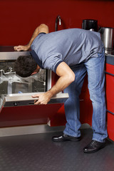 Young man looking at dish washer