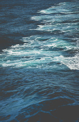 Waves behind boat while cruise through ocean in bright sun light