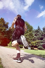 Low angle rear view of caucasian man running in park