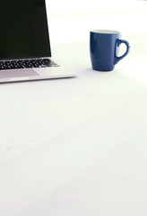 Fototapeta premium Laptop and coffee cup on white floor of office