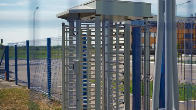 Large turnstile at the entrance to the territory. Protection against intrusion to the private area. Camera shoots through a mesh fence.