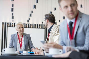 Obraz premium Confident businesswoman talking to businessman in convention center