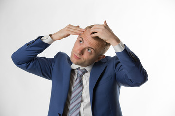 Businessman checking his hair indicating hair loss