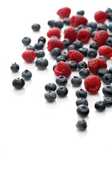 Raspberries and blueberries on white background