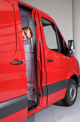 Young man peeking through van door