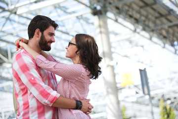 Fototapeta premium Loving couple looking at each other while embracing outside building