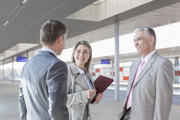 Business people conversing on train platform