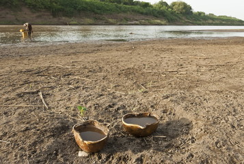 Two calabashes with water on the River Omo background, Ethiopia.