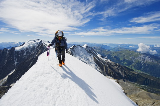 Climber on snow ridge, Aiguille de Bionnassay. on the route to Mont Blanc, French Alps, France