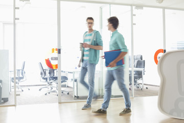 Full-length of businessmen walking at creative work space