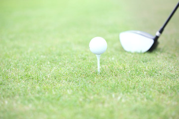 Fototapeta na wymiar Close-up of golf club and tee with ball on grass