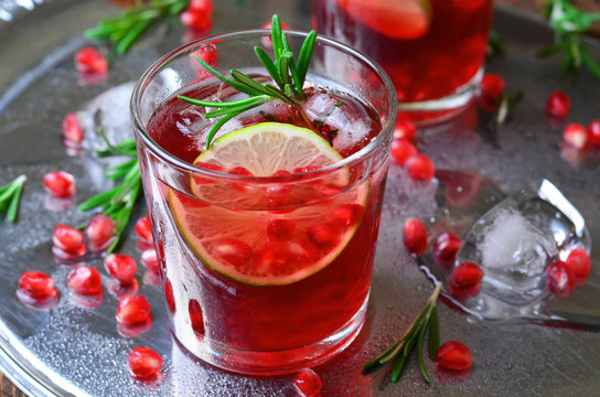 Pomegranate Cocktail Decorated with Lime, Rosemary and Ice