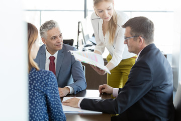 Businessmen and businesswomen in discussion with project in board room