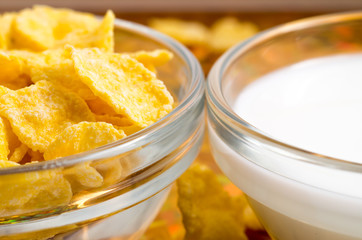 Transparent cup with milk and corn flakes close-up