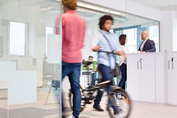 Blurred motion of colleagues with business people discussing in background at office