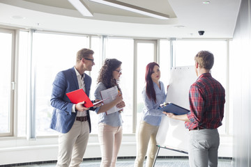 Fototapeta premium Businesswoman giving presentation to colleagues in creative office