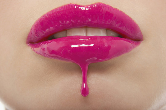 Detail Shot Of Pink Lipgloss Dripping From Woman's Lips