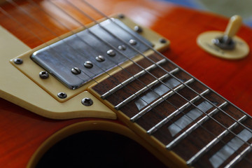 Closeup of the solid body electric guitar. Detail, selective focus, low key.