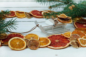 Frame for text on white wooden background with orange lemon and grapefruit chips with a wooden sled