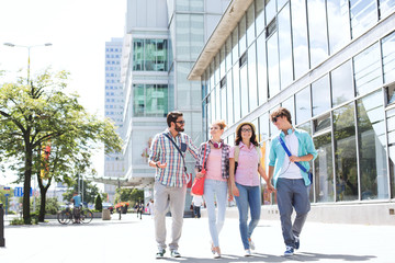 Obraz premium Full-length male and female friends walking on city street