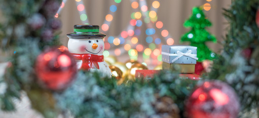 Christmas decorations and gifts with blurry lights in the background. © Marius Comanescu
