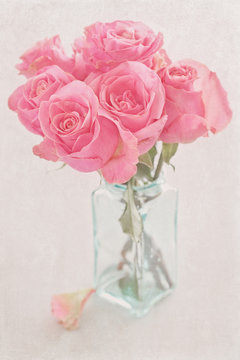Close-up floral composition with a pink roses .Many beautiful fresh pink roses on a table.Vintage style ,grunge paper background.