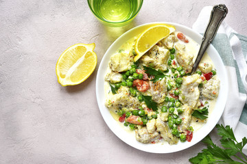 Codfish in a cream sauce with vegetables.Top view.