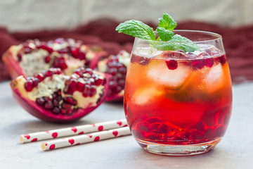 Mojito cocktail with pomegranate, mint, lemon juice and ice in glass, horizontal