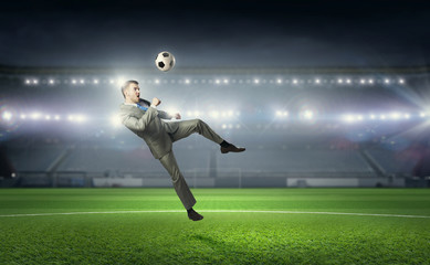 Obraz na płótnie Canvas Businessman playing soccer . Mixed media