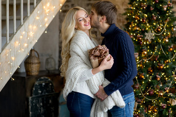 man making a Christmas gift to the pretty girl