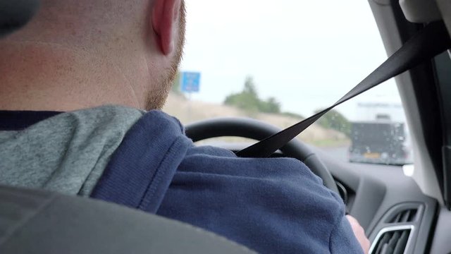 man driving car in the UK: right side driving; highway; trip, journey 