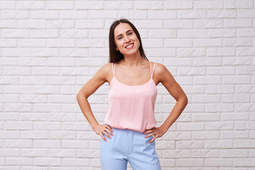Stylish Caucasian woman with hands on hips smiling at the camera