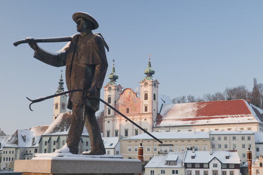 Statue honouring townspeople and Baroque Michaelerkirche church dating from 1635 at sunset, Steyr, Oberosterreich (Upper Austria), Austria
