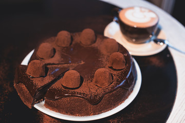 Pieces of cake. Ingredients for chocolates cake torte fruit, ice cream, chocolate chips. Slices chocolate cake on saucer. Drink hot chocolate cocoa (coffee) in cups. Black background.
